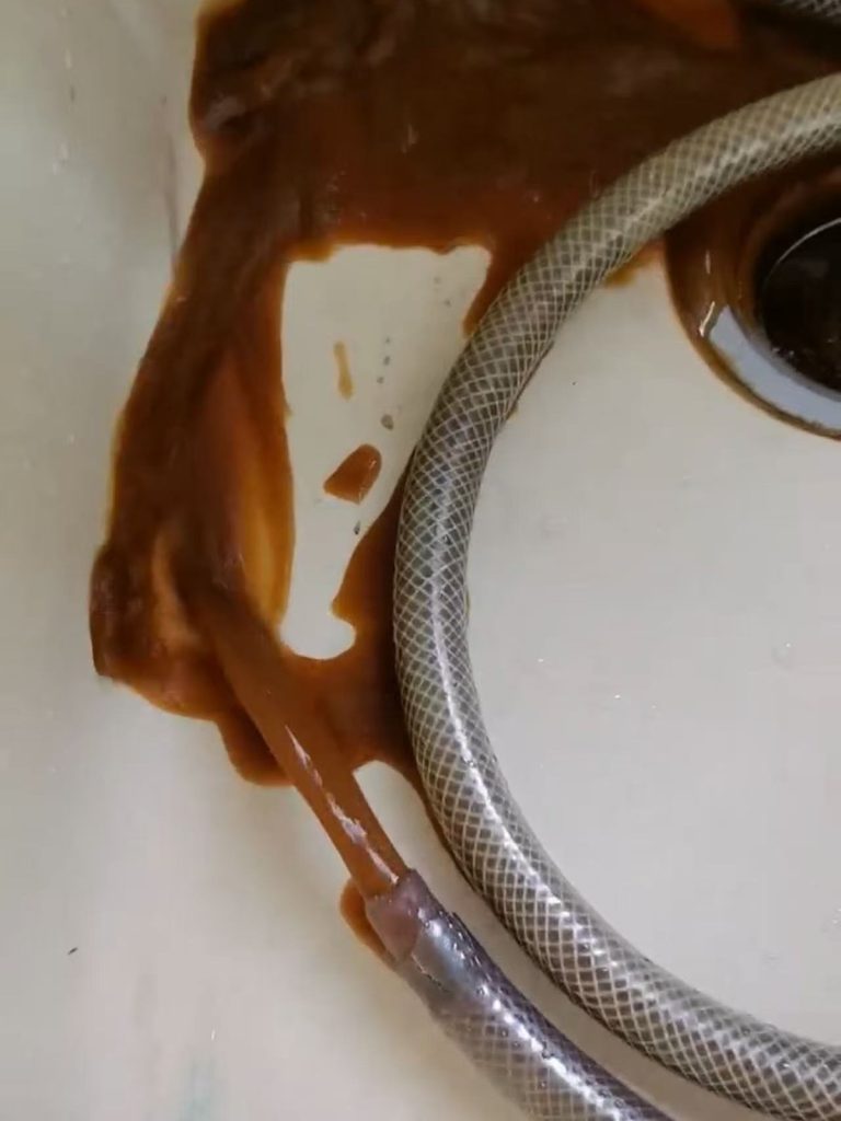 暖气片系统清洗前水质对照：黑色氧化铁杂质