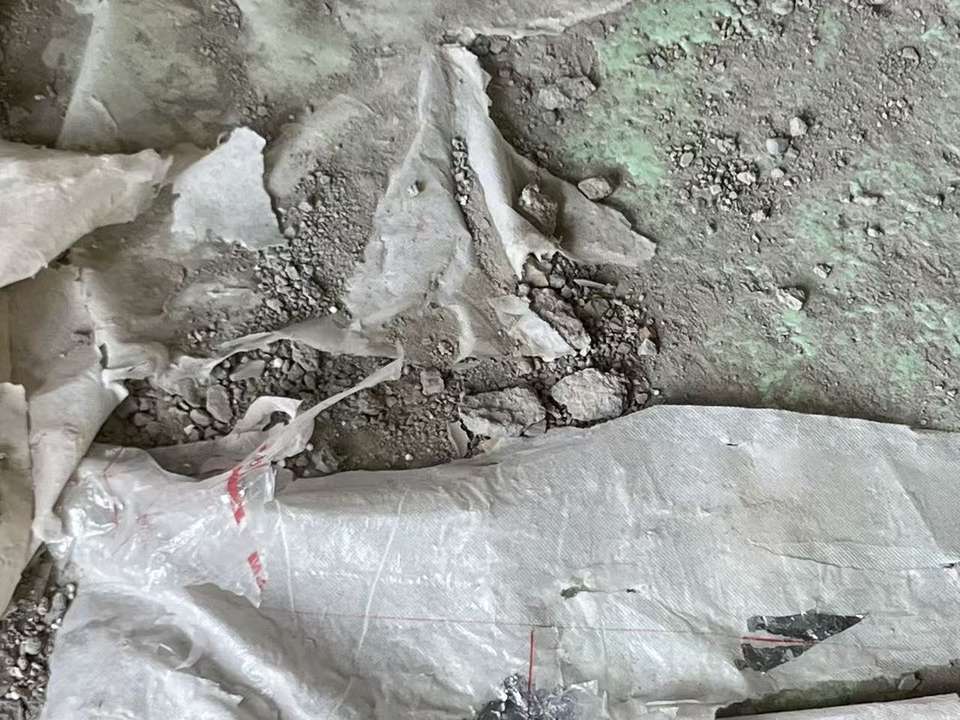 成都西派澜岸地暖拆除现场反射膜化渣03 废旧编织袋与管道